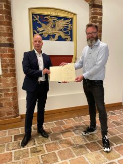 Oberbürgermeister Claus Ruhe Madsen übergibt die Ernennungsurkunde an Senator Dr. Chris Müller-von Wrycz Rekowski.