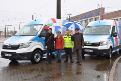 Gruppenbild vor zwei neuen Elektro-Kleinbussen
