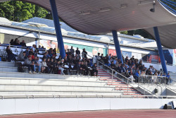 Sportlerinnen und Sportler auf der Tribüne im Leichtathletikstadion