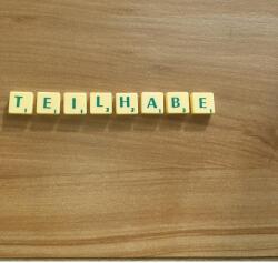 Mit Buchstabenkärtchen gelegtes Wort Teilhabe