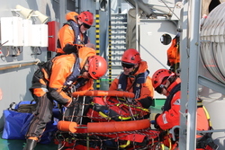 Einsatzkräfte an Bord eines Schiffes bei einer verletztenversorgungs- und Brandbekämpfungsübung