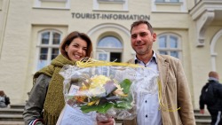 Amelie Goldbecher (links) war die 100 000. Besucherin der Tourist Information in Rostock und wurde vom Leiter René Gottschalk mit Blumen und Präsenten empfangen.
