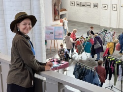 Projektkoordinatorin Nicole Gericke schaut auf das fröhliche Gewusel beim 11. „Schätzchen“-Kleidertausch in der Nikolaikirche Rostock.