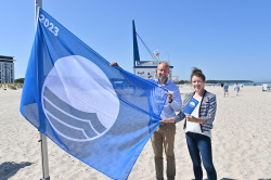 Blaue Flagge wird am Strand präsentiert