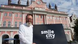 OB Claus Ruhe Madsen mit dem SMILE CITY-Logo vor dem Rathaus.