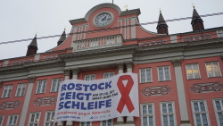 Banner "Rostock zeigt Schleife" zum Welt-Aids-Tag am 1. Dezember am Rathaus.