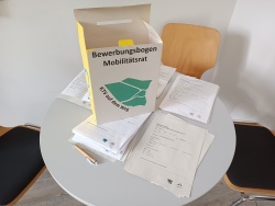 Zu sehen ist ein Tisch mit mehreren Stapeln der Bewerbungsbögen für den Mobilitätsrat. Zu sehen ist ein Tisch mit mehreren Stapeln der Bewerbungsbögen für den Mobilitätsrat.