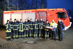 Kameradin und Kameraden der Freiwilligen Feuerwehr Rostocker Heide mit Senator Dr. Chris von Wrycz Rekowski und komm. Amtsleiter Ralf Gesk vor dem neuen Tanklöschfahrzeug TLF 5000.