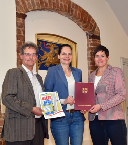 Staatssekretärin Ines Jesse (Bildmitte) übergibt den Zuwendungsbescheid an Oberbürgermeisterin Eva-Maria Kröger (r.), in Anwesenheit des Leiters des Rostocker Tiefbauamtes Heiko Tiburtius 