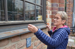 Renate Schacht begutachtet die Mängel an den Außenfenstern
