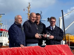 Matthias Ullrich, Thomas Wilde und Thomas Russ vom Verein „Traditionsschiff FLB 40-3“ erhalten aus den Händen von Johann Edelmann den symbolischen Schlüssel für das Boot.