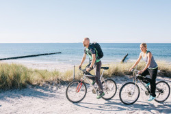 Radfahrerpaar auf einem Küstenradwanderweg an der Ostsee