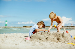 Kinder bauen eine Strandburg.