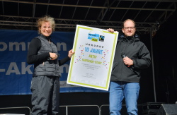 Fairtrade-Stadt-Koordinatorin Elisabeth Möser und Senator Steffen Bockhahn präsentieren die Jubiläumsurkunde 