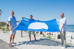 Die Blaue Flagge weht wieder in Markgrafenheide und Warnemünde v.l.n.r.: Henry Klützke (Ortsbeiratsvorsitzender Markgrafenheide), Manuel Brumme (Wachtdienstkoordinator DRK Wasserwacht) und Tourismusdirektor Matthias Fromm