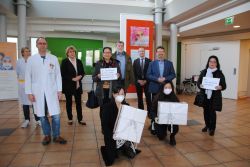 OÄ Dr. Melanie Jäckel (KSR), Prof. Dr. Jan Roesner (Ärztlicher Direktor, KSR), Sylvia Waterstradt (Pflegedienstdirektorin, KSR), Ralf Mucha (MdL, SPD),  Steffen Vollrath (Verwaltungsdirektor, KSR), Rainer Albrecht (MdL, SPD), Thy Nguyen Thi Bich (vietnamesische Unternehmerin & Näherin mit Danksageschild)