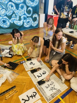 Mathilda Lange, Louisa Klingbeil und Theresa Drockner vom Musikgymnasium Käthe Kollwitz lernen die japanische Schreibkunst kennen. 