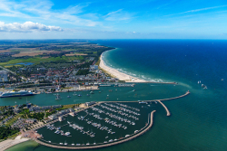 Blick über den Strand, die Promenade und die Hafenausfahrt mit den beiden Yachthäfen
